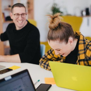 Image of two persons working and laughing.